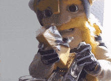 a mascot with a beard and a helmet is eating a piece of cheese