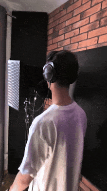 a man wearing headphones is standing in front of a microphone
