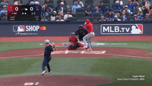 a baseball game is being played with mlb.tv advertising on the wall