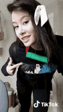 a woman wearing a bunny ear headband and a black shirt has a tiktok logo on the bottom right