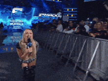 a woman speaking into a microphone in front of a sign that says smackdown
