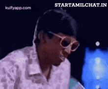 a man wearing sunglasses and a white shirt is making a funny face