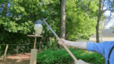 a person is holding a sword in front of a statue of a skull .