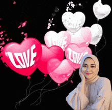 a woman wearing a hijab is standing in front of a bunch of heart shaped balloons .