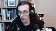 a man with long hair is wearing headphones and a microphone .
