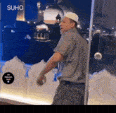 a man standing in front of a glass door with the word suho on the bottom