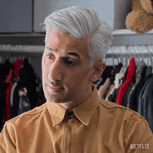 a man in a yellow shirt with a netflix logo on his chest