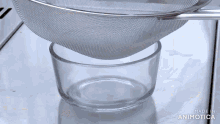 a strainer is being poured into a glass bowl and the words made in animatica are visible