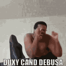 a man without a shirt is screaming with the words duxy cand debusa above him