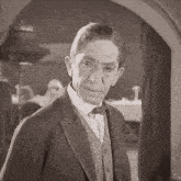 a black and white photo of a man in a tuxedo and bow tie