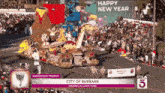 a parade in the city of burbank with a sign saying happy new year