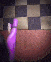 a person holding a purple object in front of a wooden wall