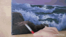 a person is painting a picture of waves on a canvas with the words made in animotica on the bottom