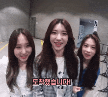 three girls are standing next to each other and one of them is wearing a white shirt with a picture of mickey mouse on it
