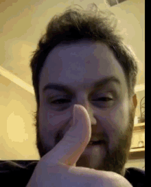 a man with a beard giving a thumbs up sign