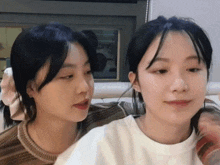 two girls are sitting next to each other and one has a ponytail in her hair
