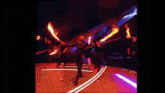 a group of people are dancing in a dark room with flames coming out of them