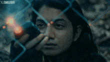 a woman is behind a chain link fence and the year 2005 is on the bottom right