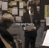 a man in a suit and tie is holding a piece of paper with the words me and twin below him