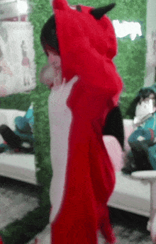 a person wearing a red devil costume with horns on their head