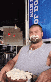 a man with his face covered in frosting is holding a cake