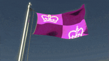 a purple flag with a crown on it is waving in the wind