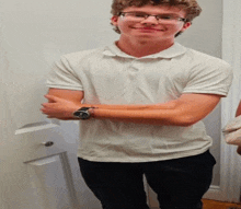 a young man wearing glasses and a watch is smiling
