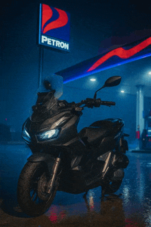 a motorcycle parked in front of a petron sign