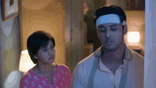 a man with a bandage on his head and a woman standing next to him