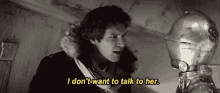 a man in a fur coat is talking to a robot and says i don 't want to talk to her .