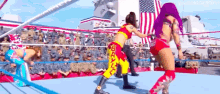 two women are wrestling in a wrestling ring in front of an american flag .