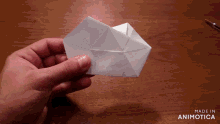 a person is holding a piece of paper that says made in animotica