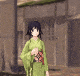 a girl in a green kimono with a black cross on her head
