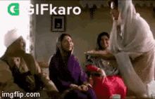 a group of women are sitting on a couch in a living room talking to each other .