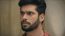a man with a beard is making a surprised face .