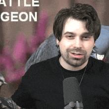 a man with a beard is talking into a microphone in front of a sign that says " battle geon "