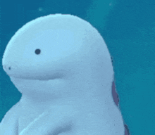 a white dolphin with a small black spot on its face is swimming in the water .