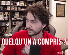 a man in a red shirt says " quelqu 'un a compris " while holding a microphone