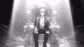 a man in a suit is sitting on a throne with a light shining on him