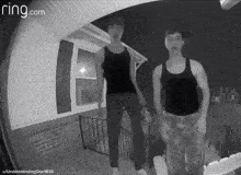 two men are standing in front of a house with ring.com written on the screen
