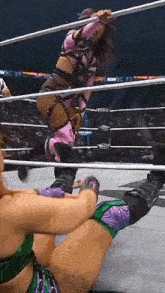 two women are wrestling in a ring with a sign that says new