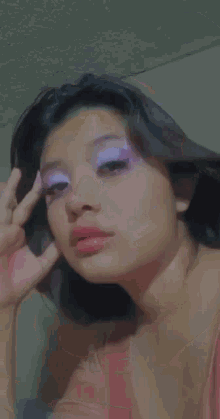 a close up of a woman 's face with purple and white eyeshadow .
