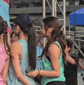 two women are standing next to each other in a crowd of people .