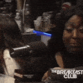 a woman sitting in front of a microphone with the breakfast club written on the bottom