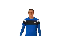 a man wearing a blue shirt with the number 30 on it waves his hand