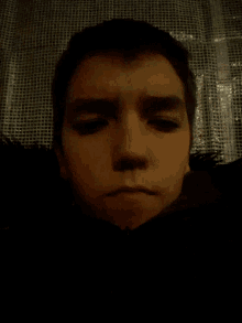 a close up of a person 's face with a black background
