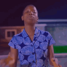 a young girl in a blue shirt is making a funny face while dancing .
