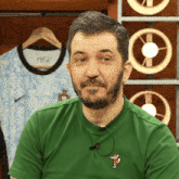 a man wearing a green shirt with a fox on the front