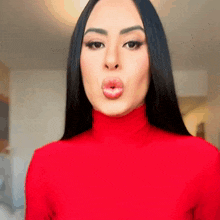 a woman in a red turtleneck is making a funny face
