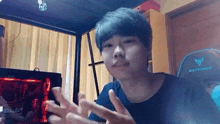 a young man is standing in front of a computer .